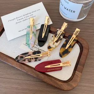 Chic 6-piece acetate hair clip set in marble and tortoiseshell finishes on a wooden tray