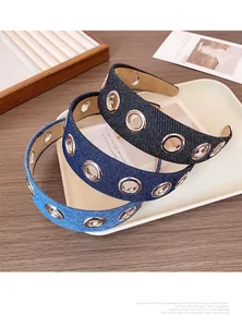 Détail de serre-têtes en denim bleu avec œillets argentés sur fond en bois vintage