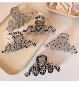 Detail of wavy leopard print hair claw clips with strong gold metal springs for women