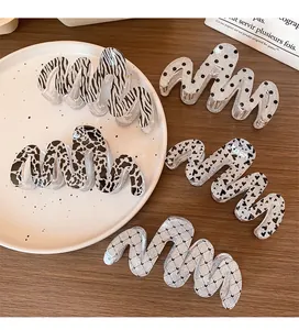 Detail of glitter resin claw clips with animal and heart prints on a ceramic tray