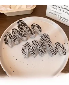 Detailed view of wave hair claws in cow and zebra prints with glitter accents