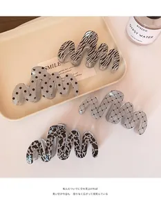 Set of four large wavy hair claws in leopard, zebra, and polka dot patterns on a tray