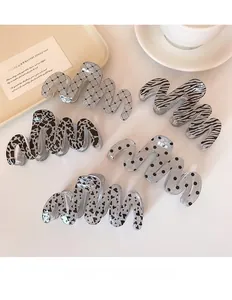Close-up of glitter wave hair claws in zebra, leopard, and polka dot patterns set