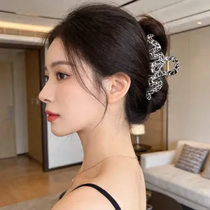 Brown leopard pattern wavy hair claw clip showing secure hold on a half-up hairstyle