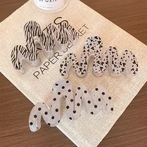 Three wavy acrylic shark hair clips with zebra, heart and polka dot glitter patterns