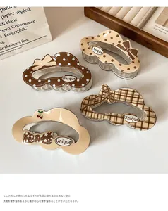 Detail view of cloud-shaped hair claws with polka dots, plaid patterns and bows