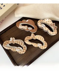 Detail of four Korean cloud hair claws with brown patterns on a wooden tray