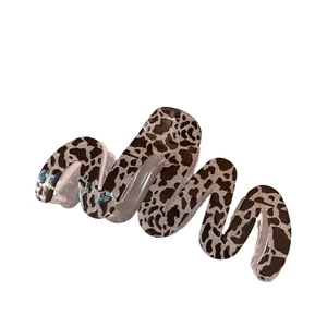 Elegant wavy shark hair clip with leopard print and silver glitter on white background