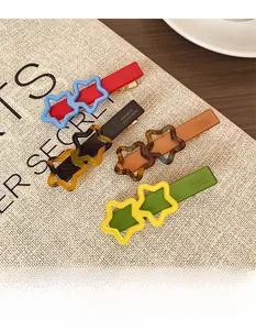 Détail de quatre barrettes étoiles colorées avec gravure France Handmade sur le clip