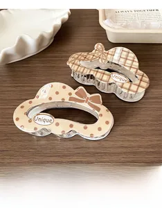 Detail of plaid and polka dot bow hair clips on wooden table with elegant styling