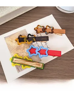 Détail de barrettes étoiles colorées affichant le logo France Handmade sur clips dorés