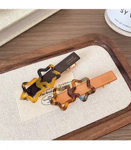 Détail de pinces à cheveux étoile en écaille avec lettrage France Handmade gravé