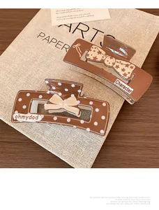 Close-up of coffee brown hair claws with decorative ribbons and elegant patterns