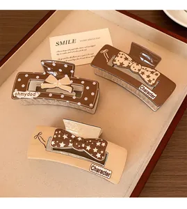Detailed view of coffee-colored hair claws featuring polka dots and star patterns
