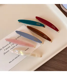 Dettaglio di 6 fermagli per capelli a foglia fatti a mano in colori opachi con scritte oro
