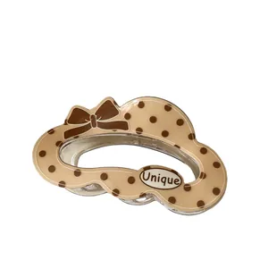 Cute beige cloud hair claw clip with brown polka dots and a bow tie accent