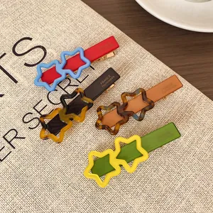Lot de quatre barrettes étoiles faites main aux couleurs vives sur tissu en lin beige