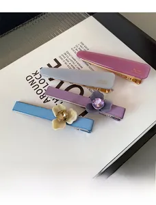Détail de barrettes à fleurs en acétate avec cristaux brillants et tons pastel doux