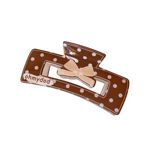 Brown polka dot hair claw clip with beige bow and ohmydod logo for thick hair