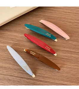 Dettaglio di cinque fermagli per capelli colorati in stile francese su legno