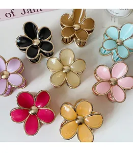 Detail of candy-colored gradient flower hair claws with elegant gold-rimmed resin petals