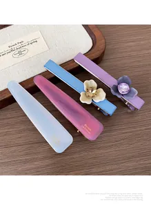 Détail de barrettes à fleurs en acétate avec pierres précieuses sur table en bois