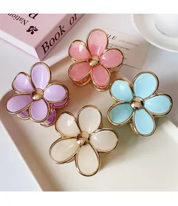 Detailed view of pastel flower hair claws with gold edges in a decorative tray