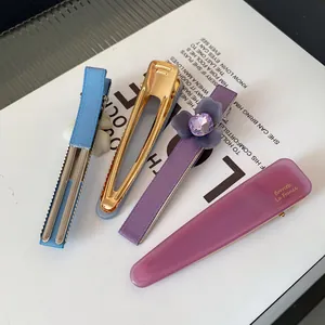 Lot de barrettes à cheveux fleurs en acétate avec rubans et cristaux sur un magazine