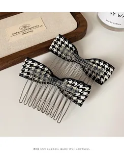 Close-up of elegant houndstooth bow hair combs with metal teeth on a rustic wooden tray