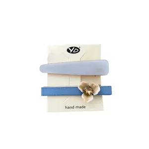 Ensemble de barrettes à fleurs en acétate bleu avec détails dorés sur support blanc