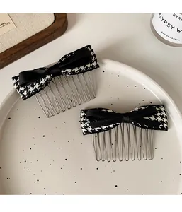 Detailed view of two houndstooth bow hair combs on a white ceramic plate for hair styling