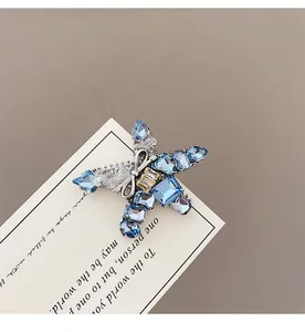 Macro detail of star and bow hair clip with light blue crystals and yellow gemstone