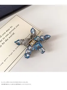 Macro view of blue and yellow crystal butterfly clip with intricate silver metal setting