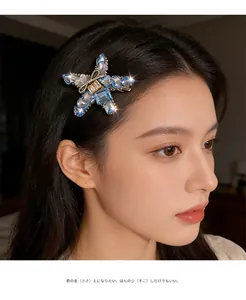 Detail of star-shaped hair clip with light blue crystals and small metal bow on a model