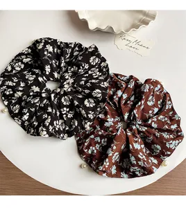 Close-up of floral scrunchies with white pearls in black and brown patterns