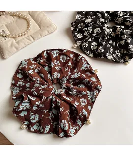 Detail of floral chiffon oversized scrunchies with elegant faux pearl embellishments