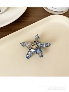 Detailed close-up of a blue star-shaped rhinestone hair clip with silver bow decoration