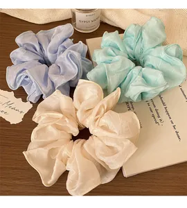 Trois chouchous géants en organza aux couleurs pastel violet, vert menthe et blanc crème