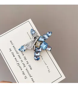 Macro detail of star-shaped brooch with light blue crystals and silver bow accent