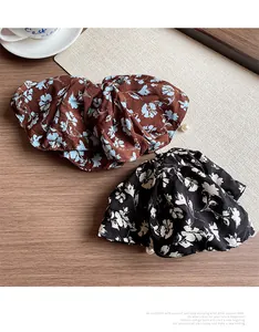 Detail of floral scrunchies with pearl trim on wooden desk with ceramic coffee cup