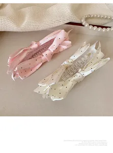 Détail des élégantes barrettes en satin à pois roses et blancs avec des perles