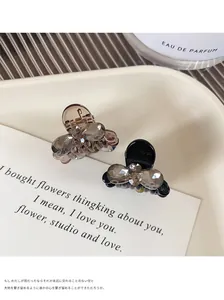 Detailed view of two elegant bow hair clips with crystals on a ceramic tray