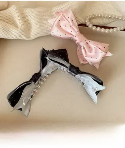 Détail de pinces à cheveux avec nœud en satin à pois sur un fond élégant et raffiné