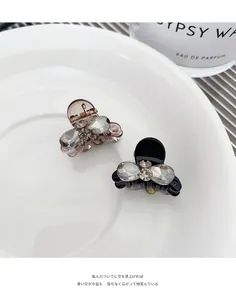 Macro view of small bow hair clips with grey rhinestones in translucent and black colors
