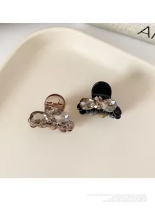 Close-up of small bow hair clips with rhinestones in black and amber colors
