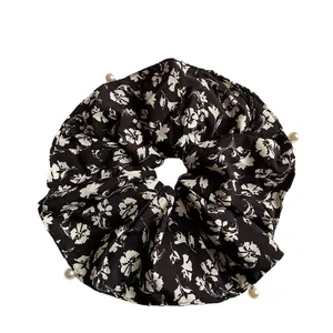 Elegant black floral scrunchie with white flower print and decorative pearls