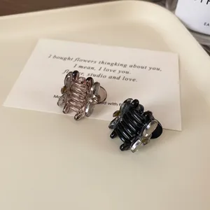 Set of two mini bow hair clips in translucent amber and black resin on a tray