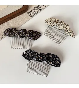 Detail of floral bow hair combs in navy, black and beige with silver metal teeth