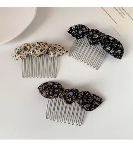 Detailed view of floral bow hair combs in three patterns on a minimalist background