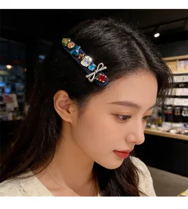 Detail of denim hair clip with rhinestones, colorful gems, and silver bow on model